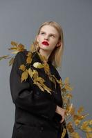 glamorös kvinna dekorationer svart jacka gyllene löv studio modell oförändrad foto