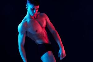 ung man med atletisk fysik visar muskler pumpade upp torso kroppsbyggare kondition modell foto