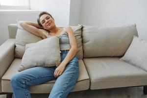 en kvinna bär glasögon sitter på en soffa och utseende på de kamera. syn problem foto