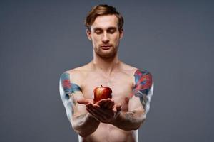 atletisk män bodybuilding kondition Tryck pumpade upp ärm muskler tatuering röd äpple foto