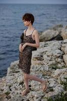 skön kvinna i klänning på natur stenar landskap elegans foto