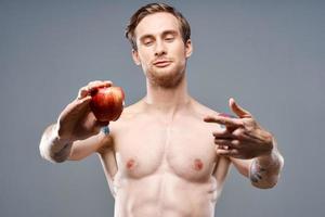 atletisk man med en taggad torso och en tatuering på hans ärm röd äpple hälsa foto