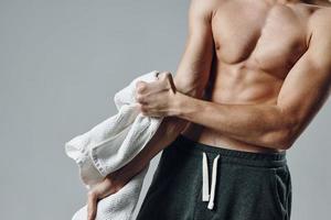 sportig man med pumpade muskulös kropp beskurna se studio träna handdukar i händer foto
