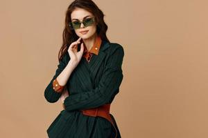 kvinna bär solglasögon Framställ mode livsstil beige bakgrund foto