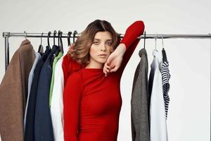 skön kvinna i en röd jacka nära de garderob isolerat bakgrund foto