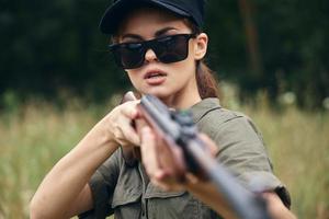 kvinna på utomhus- i solglasögon vapen i hand färsk luft foto