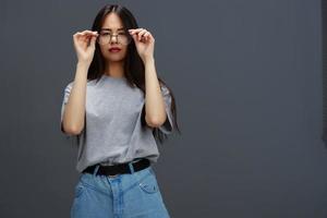 Söt kvinna glasögon på ansikte mode livsstil grå t-shirt isolerat bakgrund foto
