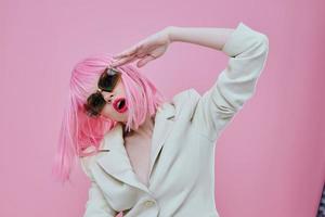 skön modern flicka bär solglasögon rosa hår Framställ rosa bakgrund oförändrad foto
