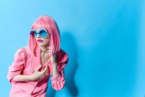 Söt kvinna i blå glasögon bär en rosa peruk studio modell oförändrad foto