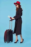 kvinna i svart täcka bagage flygplats resa blå bakgrund företag resa foto