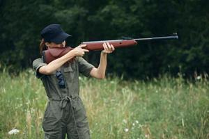 kvinna på natur med en pistol i hans händer, siktar en grön overall vapen foto