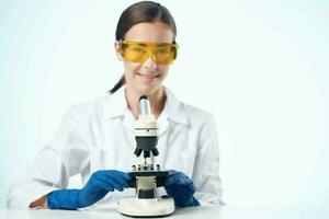kvinna i vit täcka laboratorium mikroskop forskning bioteknik foto