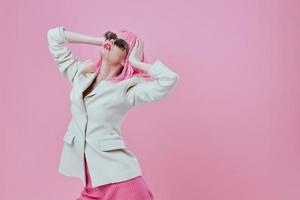 porträtt av en charmig lady modern stil rosa hår solglasögon rosa bakgrund oförändrad foto
