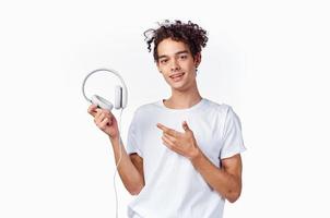 tonåring bär hörlurar ny teknologi vit t-shirt isolerat bakgrund musik modell foto