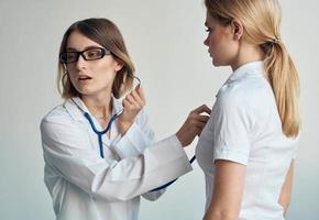 hälsa problem kvinna patient och professionell läkare glasögon modell stetoskop foto