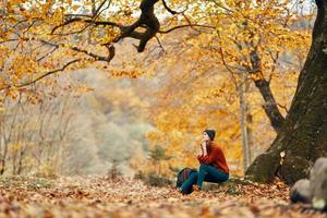 kvinna i de parkera landskap faller löv resa natur höst modell ryggsäck foto
