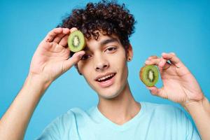 glad kille blå t-tröjor kiwi i de händer av vegetarianism frukt foto