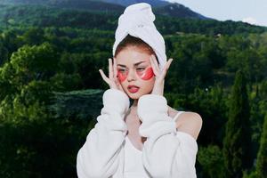 sensuell och skön kvinna med plåster på de ansikte i en morgonrock avslappning begrepp foto
