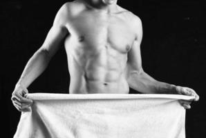 en man med en taggad kropp omslag han själv med en handduk studio kondition foto