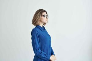 företag kvinna i blå skjorta bär glamour glasögon Framställ ljus bakgrund foto
