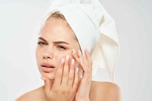 kvinna med handduk på huvud hud vård dermatologi missnöje problem foto