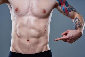manlig idrottare med kuber på hans mage naken torso tatuering kroppsbyggare kondition foto