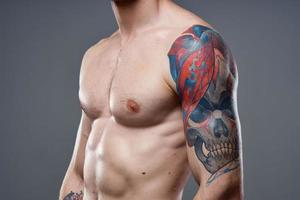 sportig man med pumpade upp Tryck tatuering på hans vapen macho beskurna se foto