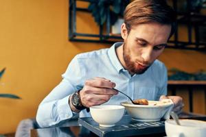 företag man i blå skjorta har lunch på en Kafé tabell foto