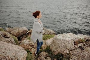 Söt kvinna frihet promenad på de sten kust livsstil foto