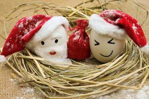 Lycklig ägg med målad ansikten i de bo för jul foto