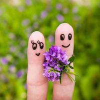 finger konst av en Lycklig par. man är ger blommor till en kvinna. foto