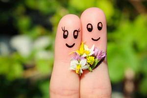 finger konst av en Lycklig par. man är ger blommor till en kvinna. foto