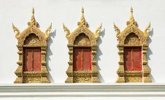 gyllene fönster ram på vit betong vägg i tempel. thai stil dekoration av mönster foto