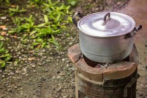gammal smutsig matlagning pott och skål kokt vatten med ånga på träkol spis foto