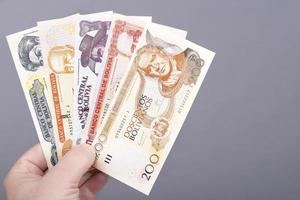 bolivian pengar i de hand på en grå bakgrund foto