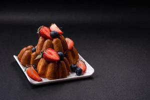 utsökt muffins eller muffins med russin och nötter, jordgubbar och blåbär foto