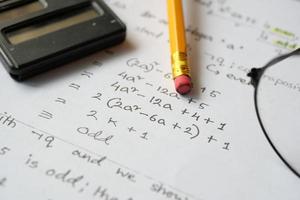 hand skriva algebra ekvationer på ett papper foto