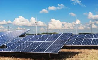 elektricitet kraft i natur. rena energi begrepp. sol- panel med turbin och blå himmel bakgrund foto