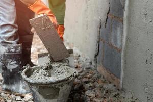 arbetstagare putsning cement på vägg för byggnad hus foto