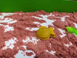 röd sand bygga för unge leksaker med gjutning. Foto är lämplig till använda sig av för leksaker bakgrund och unge utbildning innehåll media