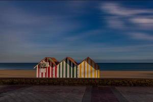 fredlig havet landskap med tre färgrik trä- hus strand och semester foto