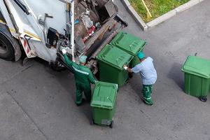 sopor män läser in hushåll skräp i sopor lastbil, se från ovan foto