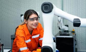 i ett elektronisk delar anläggningen, kvinna ingenjörer i de växt, inspekterande och testning robot händer Begagnade i de produktion av elektronisk komponenter. foto