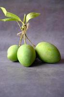 färsk grön mango på svart bakgrund foto
