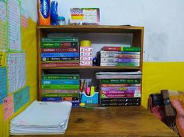 rangpur, bangladesh 2023. bok hylla på de table.stack av böcker och pennor i hållare, utbildning begrepp bakgrundsböcker på en trä- hyllor. foto