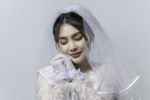 porträtt av asiatisk kvinna ha på sig brud med blomma på vit bakgrund, bröllop begrepp foto