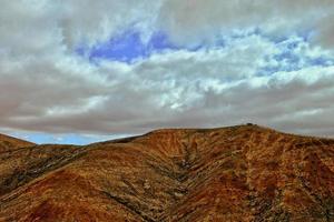 tömma mystisk bergig landskap från de Centrum av de kanariefågel ö spanska fuerteventura med en molnig himmel foto