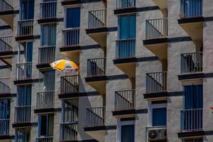 bakgrund av ett lägenhet blockera med balkonger och ett gul paraply foto