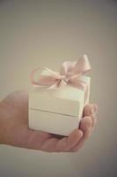 en gåva i en vit låda med en rosa rosett foto