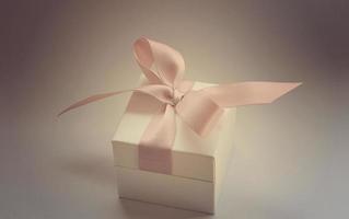 en gåva i en vit låda med en rosa rosett foto